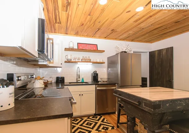 a kitchen with stainless steel appliances granite countertop a sink a stove and a refrigerator