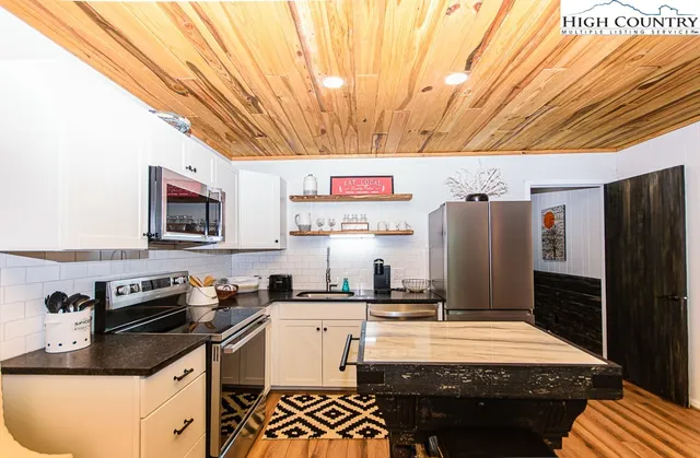 a kitchen with stainless steel appliances kitchen island granite countertop a refrigerator and a stove top oven
