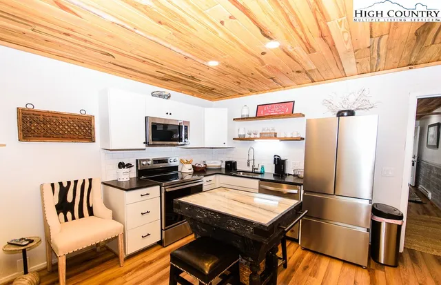 a kitchen with stainless steel appliances granite countertop a refrigerator and a stove top oven