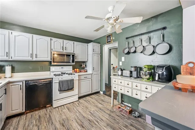 a kitchen with a stove cabinets and wooden floor