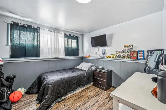 a bedroom with a bed and a flat screen tv