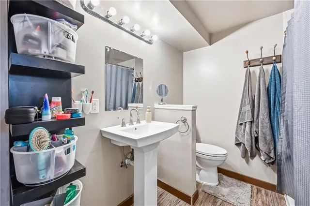 a bathroom with a sink mirror vanity and toilet