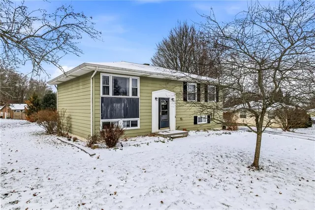 a front view of a house with a yard covered in snow