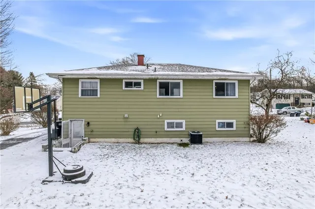 a view of a backyard with chairs and potted plants