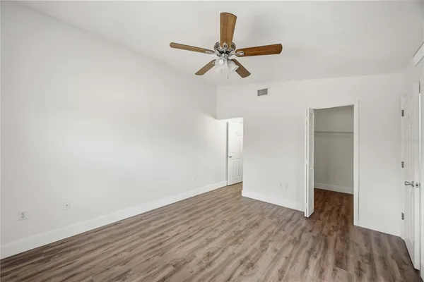 a view of a room with wooden floor and ceiling fan