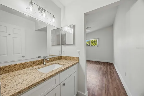 a bathroom with a granite countertop sink and a mirror