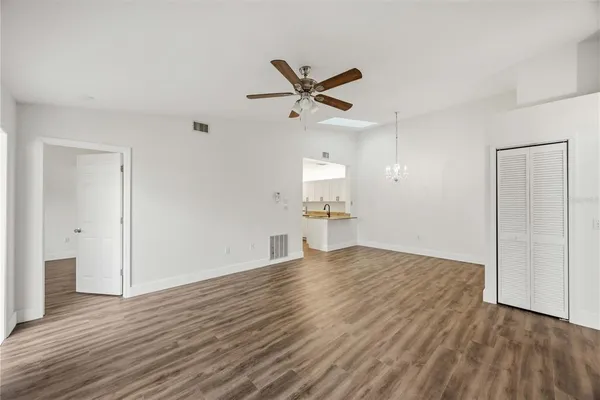a view of empty room with wooden floor and ceiling fan
