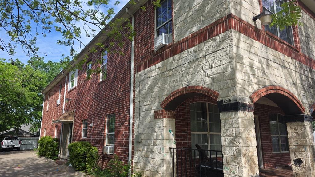 609 Elwayne Avenue Dallas, TX 75217 - Photo 2 of 9 Brick and stone exterior featuring arched entryways and multiple windows