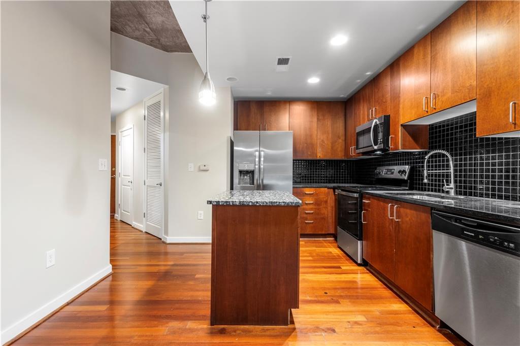 250 Pharr Road Northeast, Unit 308 Atlanta, GA 30305 - Photo 2 of 35 a large kitchen with stainless steel appliances granite countertop a stove a sink and a refrigerator