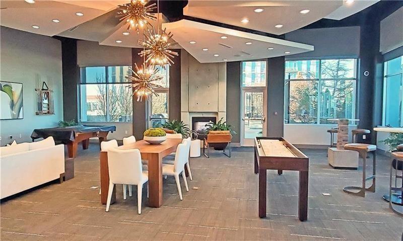 250 Pharr Road Northeast, Unit 308 Atlanta, GA 30305 - Photo 27 of 35 a dining room with wooden floor a chandelier a glass table and chairs