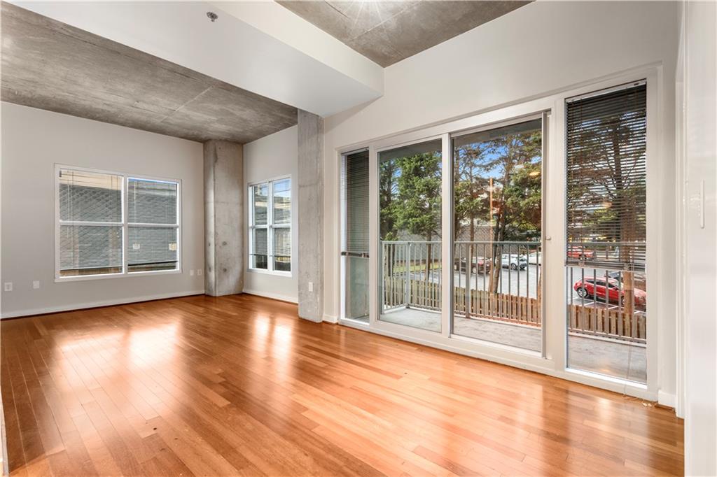 250 Pharr Road Northeast, Unit 308 Atlanta, GA 30305 - Photo 4 of 35 a view of empty room with wooden floor and floor to ceiling window