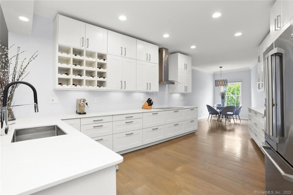13 Old Stamford Road, Unit 13 New Canaan, CT 06840 - Photo 12 of 39 a large white kitchen with wooden floors and white stainless steel appliances