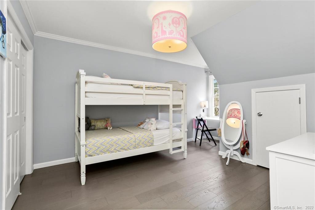 13 Old Stamford Road, Unit 13 New Canaan, CT 06840 - Photo 16 of 39 a bedroom with a bed and a chandelier