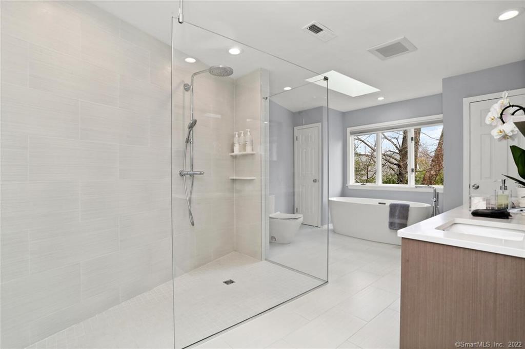 13 Old Stamford Road, Unit 13 New Canaan, CT 06840 - Photo 23 of 39 a bathroom with a tub sink mirror and a shower