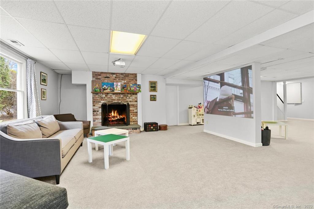 13 Old Stamford Road, Unit 13 New Canaan, CT 06840 - Photo 25 of 39 a living room with furniture and a fireplace