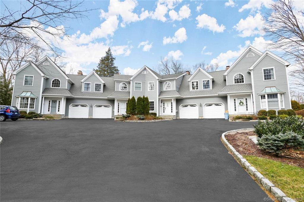 13 Old Stamford Road, Unit 13 New Canaan, CT 06840 - Photo 36 of 39 a front view of a house with a garden and trees