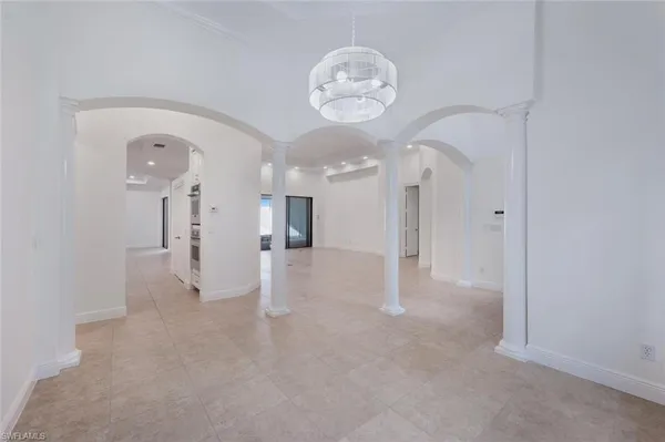 a view of a big room with chandelier fan and windows