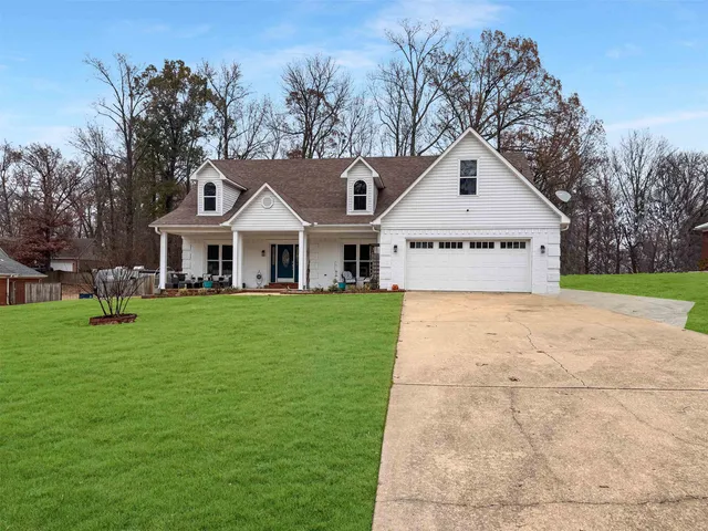 a front view of a house with a yard and trees
