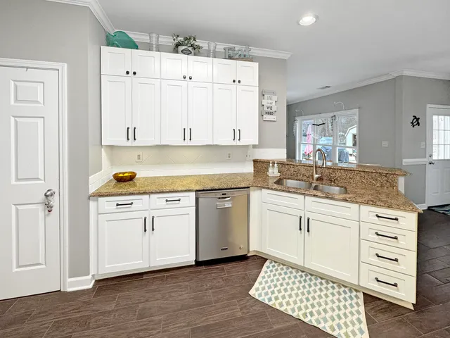 a kitchen with granite countertop white cabinets and white appliances