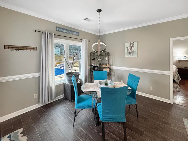 a dining room with furniture a chandelier and wooden floor