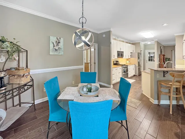 a view of a dining room with furniture a chandelier and wooden floor