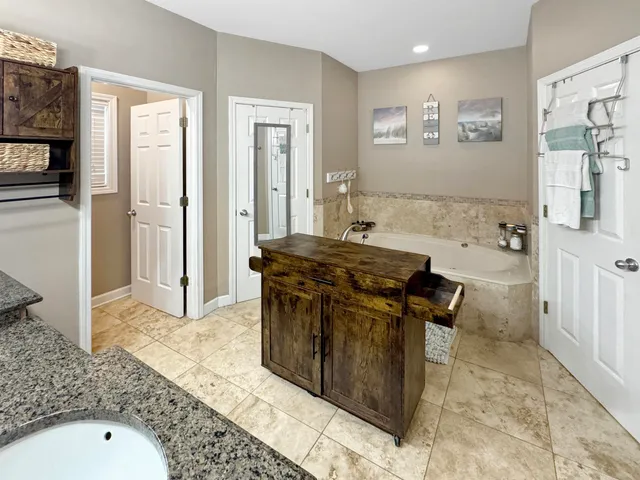 a living room with stainless steel appliances kitchen island granite countertop a refrigerator and a sink