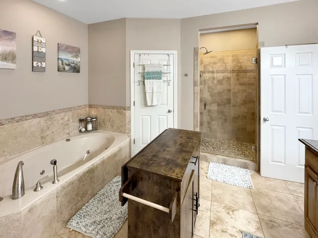 a spacious bathroom with a tub a sink and a shower