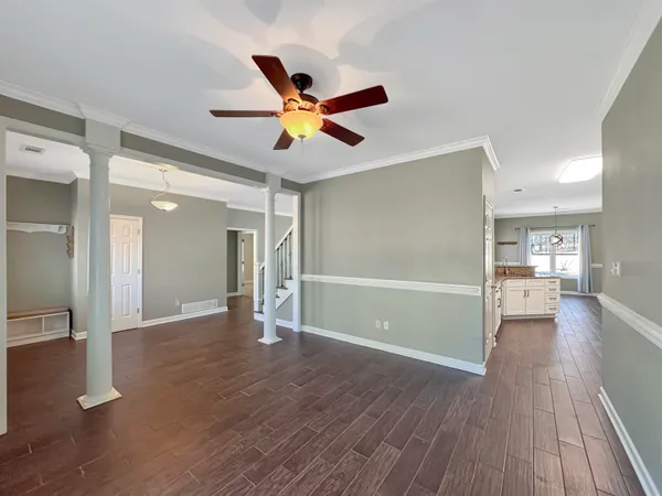 a view of an empty room with a chandelier fan