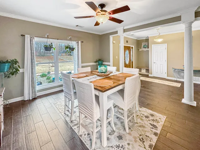 a dining room with wooden floor and large window