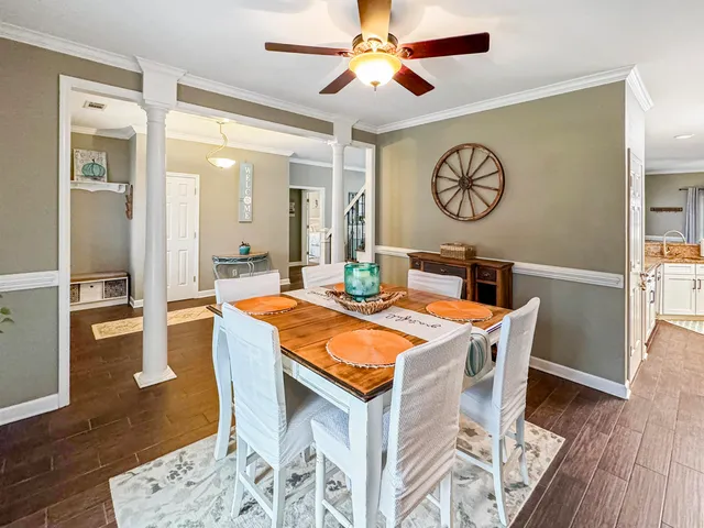 a dining room with wooden floor a glass table and chairs