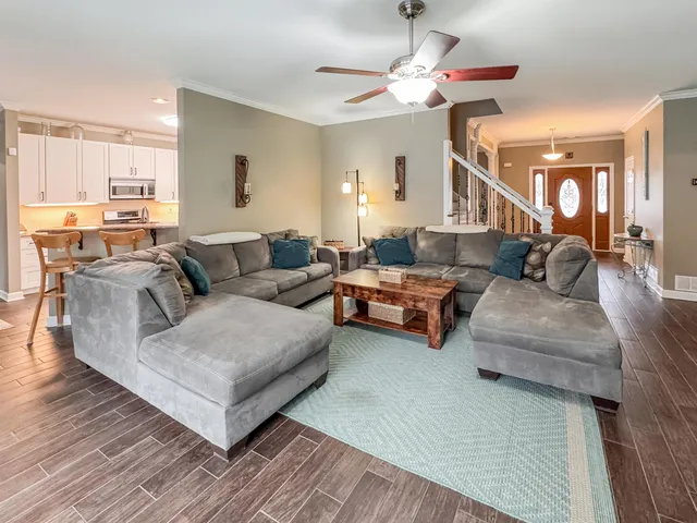 a living room with furniture and a wooden floor