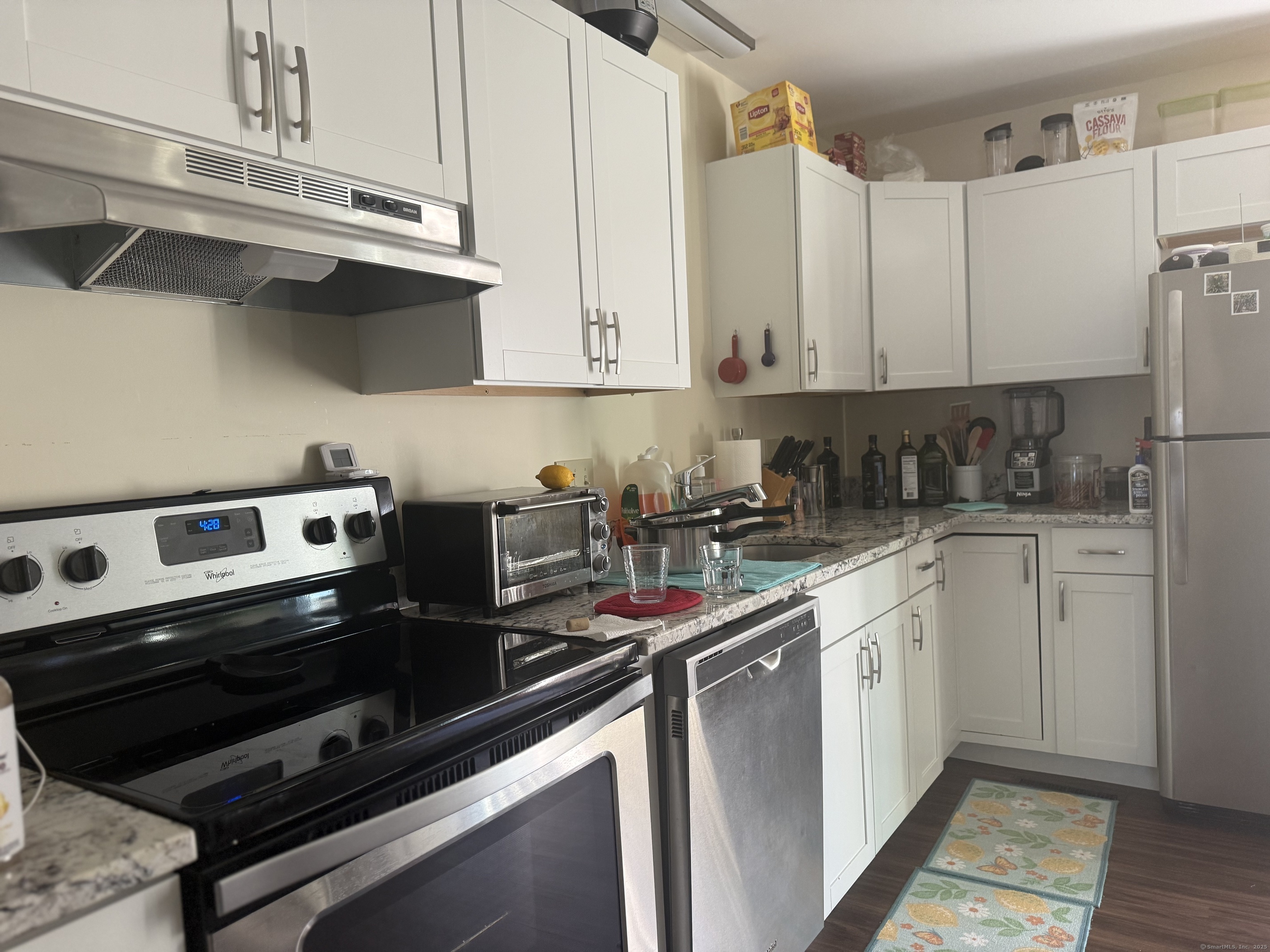 87 Gerrish Avenue, Unit T2 East Haven, CT 06512 - Photo 3 of 12 a kitchen with stainless steel appliances a sink dishwasher a stove and white cabinets