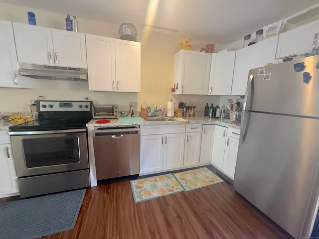 a kitchen with a white stove top oven and refrigerator