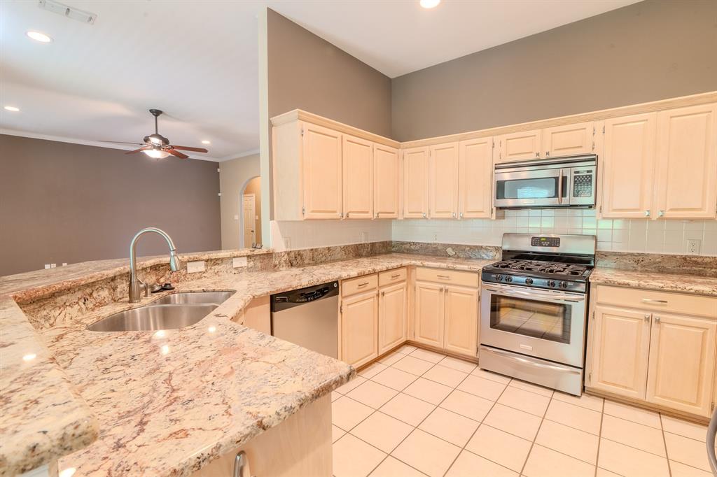 6014 Brenhaven Road Arlington, TX 76017 - Photo 1 of 18 Kitchen featuring light-toned cabinetry, stainless steel appliances, and a tile backsplash