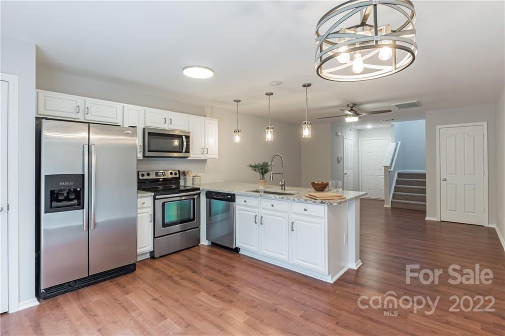 433 Hunters Dance Road Fort Mill, SC 29708 - Photo 7 of 25 a kitchen with stainless steel appliances kitchen island granite countertop a refrigerator and a stove top oven