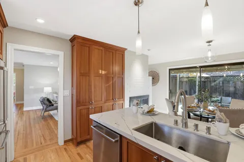 a kitchen with a sink a counter and a view of living room