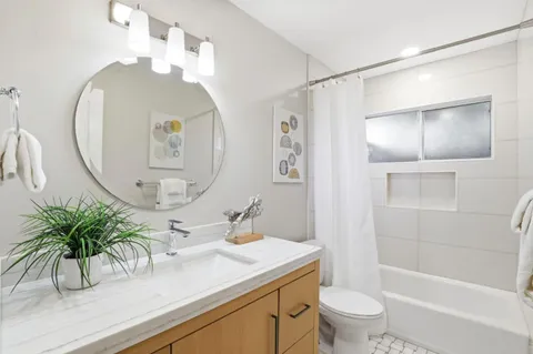 a bathroom with a sink a toilet and a mirror