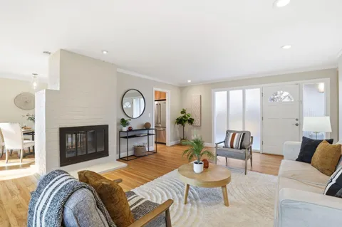 a living room with furniture a fireplace and a large window