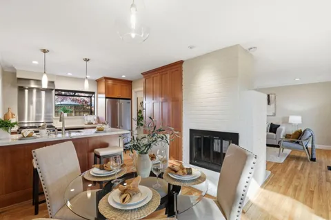 a dining room with furniture a fireplace and wooden floor
