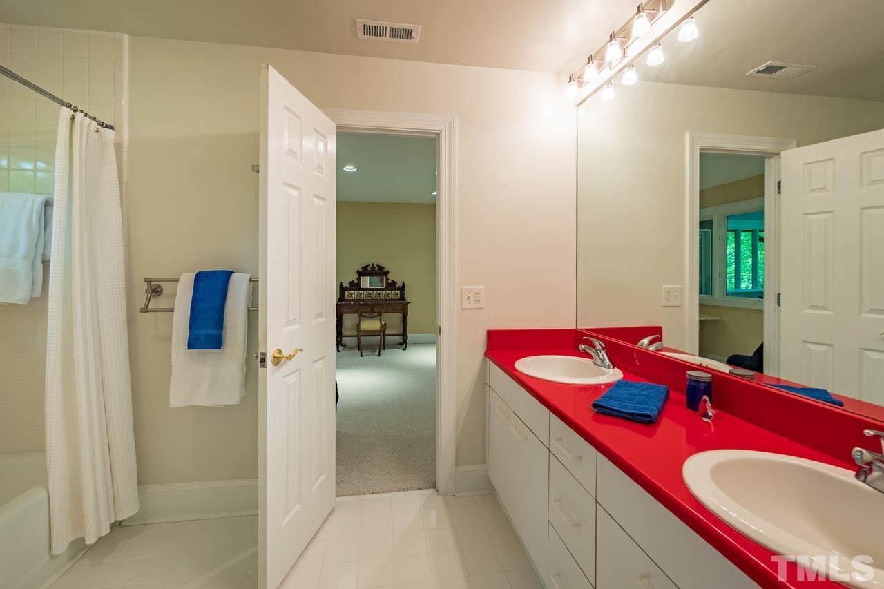 5415 Taproot Lane Durham, NC 27705 - Photo 24 of 30 a bathroom with a sink vanity granite shower and a mirror