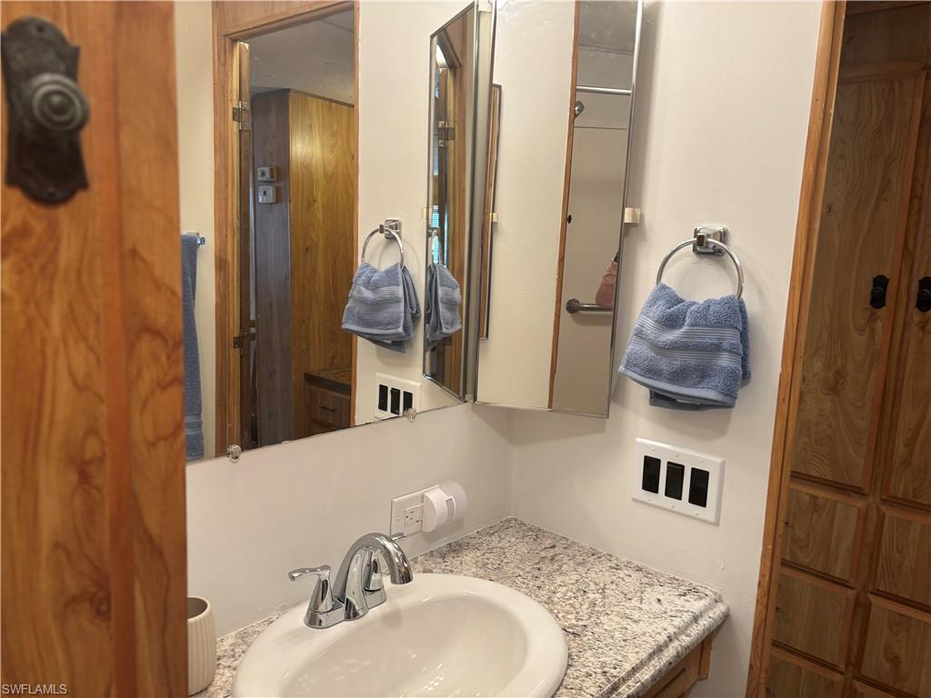 10 Jade Drive, Unit 10J Naples, FL 34114 - Photo 15 of 21 a bathroom with a sink and a mirror