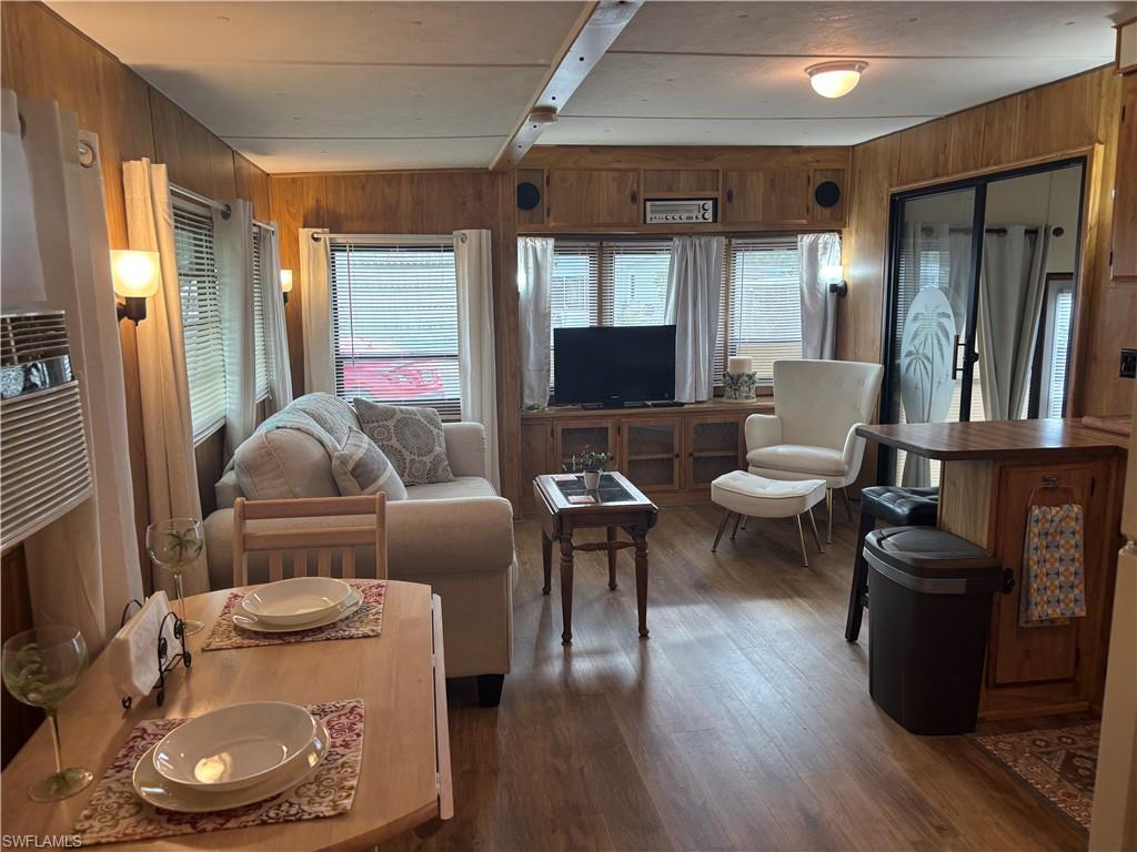 10 Jade Drive, Unit 10J Naples, FL 34114 - Photo 18 of 21 a living room with furniture a wooden floor and a large window