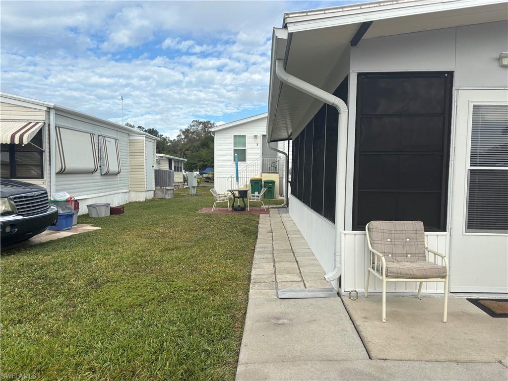 10 Jade Drive, Unit 10J Naples, FL 34114 - Photo 4 of 21 a backyard of a house with table and chairs