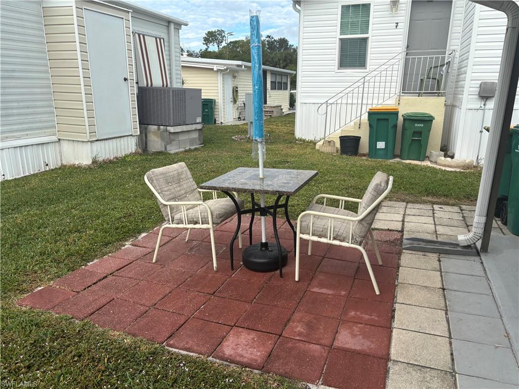 10 Jade Drive, Unit 10J Naples, FL 34114 - Photo 5 of 21 a view of a patio with table and chairs and potted plants