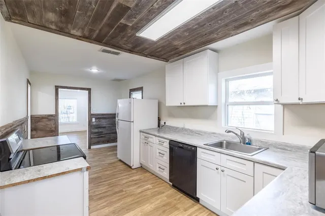 a kitchen with refrigerator and cabinets