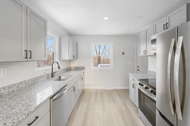 a kitchen with granite countertop a sink and a window