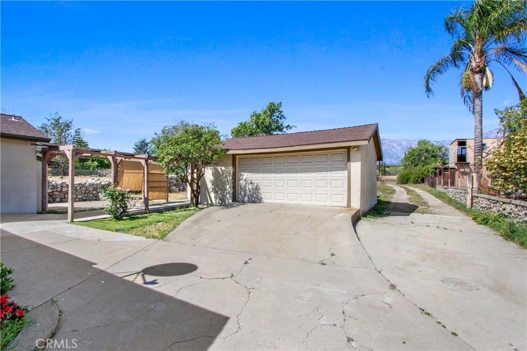 8410 Arrow Route Rancho Cucamonga, CA 91730 - Photo 18 of 24 a white house with a small yard and a large parking space