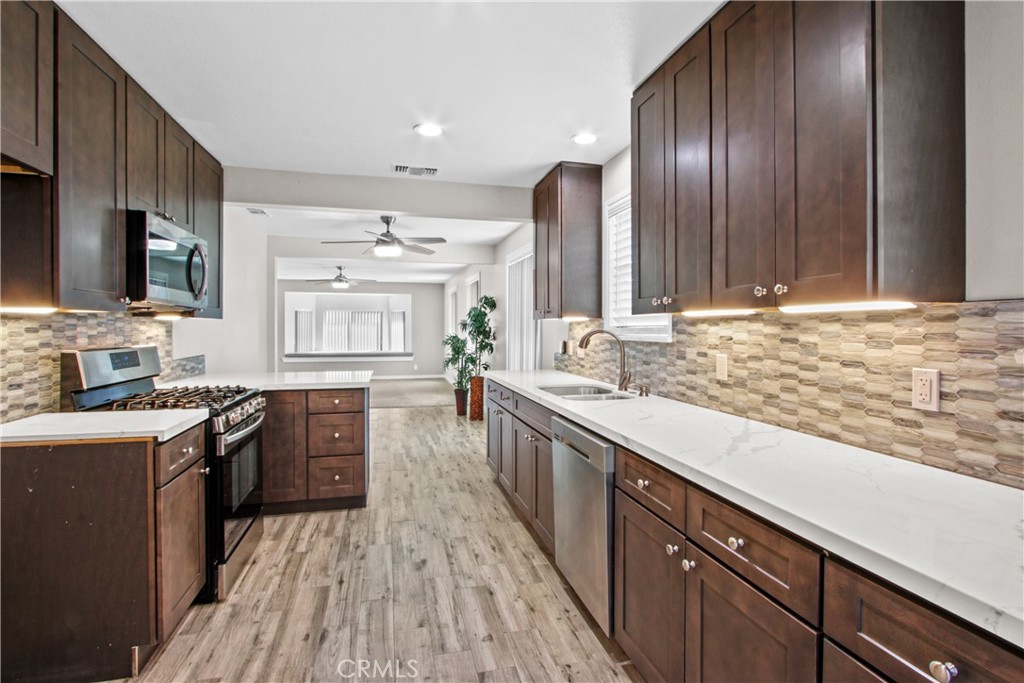 8410 Arrow Route Rancho Cucamonga, CA 91730 - Photo 10 of 24 a kitchen with stainless steel appliances granite countertop wooden cabinets a stove top oven a sink and dishwasher