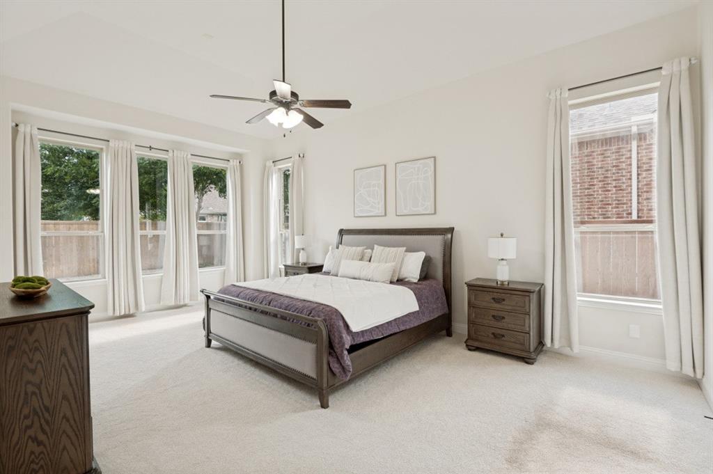 14215 Raspberry Lane Frisco, TX 75035 - Photo 9 of 30 Carpeted bedroom featuring an upholstered bed frame, a multi-window wall with floor-length drapes, a ceiling fan with integrated lighting, and a wood-finish dresser