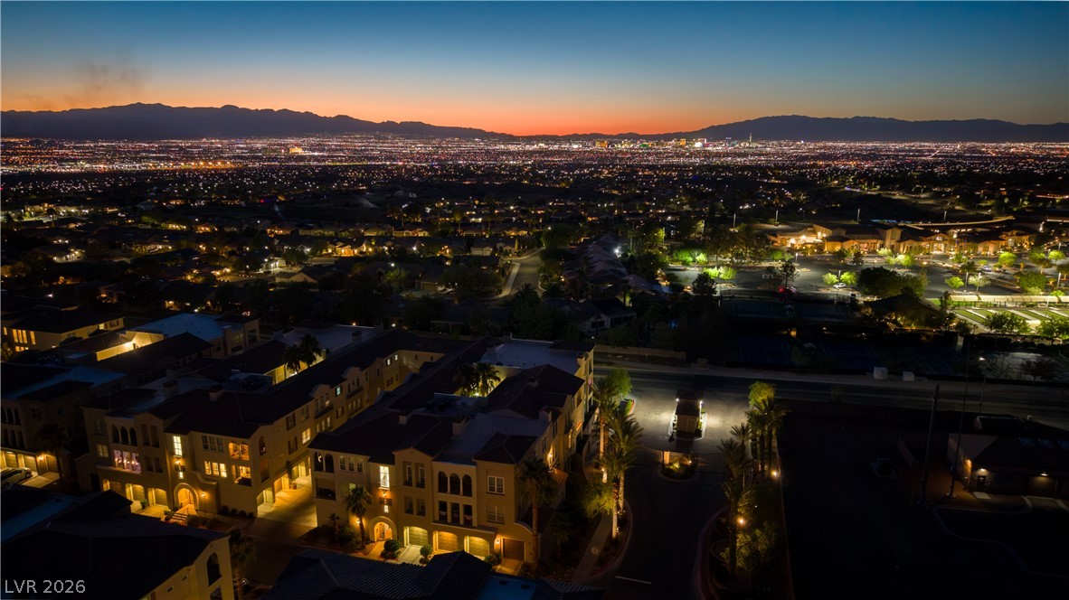 2555 Hampton Road, Unit 3308 Henderson, NV 89052 - Photo 49 of 65 City lights illuminate the twilight sky, revealing a community nestled among distant mountains.